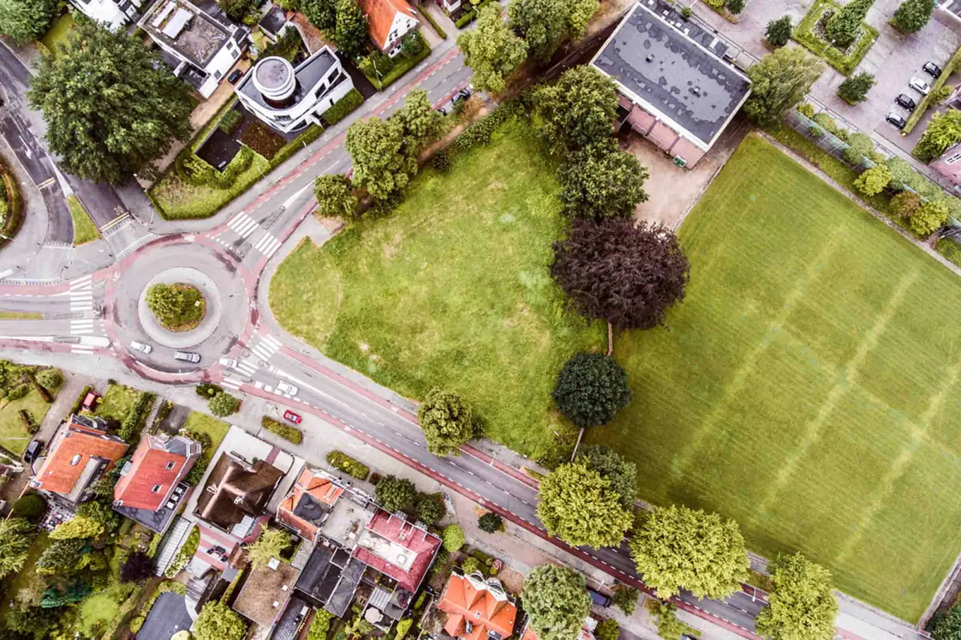 Aerial view of an undeveloped plot between streets and homes (illustrative image)